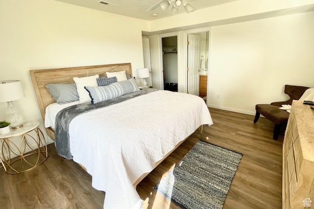 bedroom with a closet, ensuite bath, ceiling fan, and dark hardwood / wood-style flooring