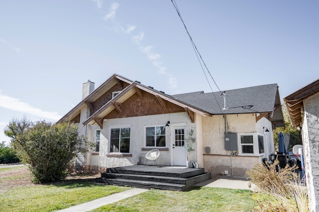 rear view of property featuring a lawn