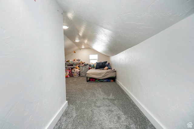 carpeted bedroom featuring a textured ceiling and lofted ceiling