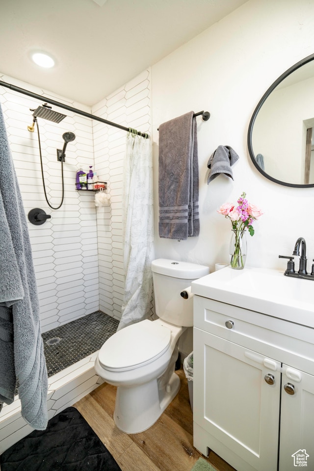 bathroom with vanity, toilet, a shower with shower curtain, and hardwood / wood-style flooring