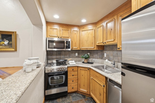 kitchen featuring decorative backsplash, appliances with stainless steel finishes, and sink