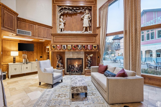 living room with a towering ceiling and wood walls