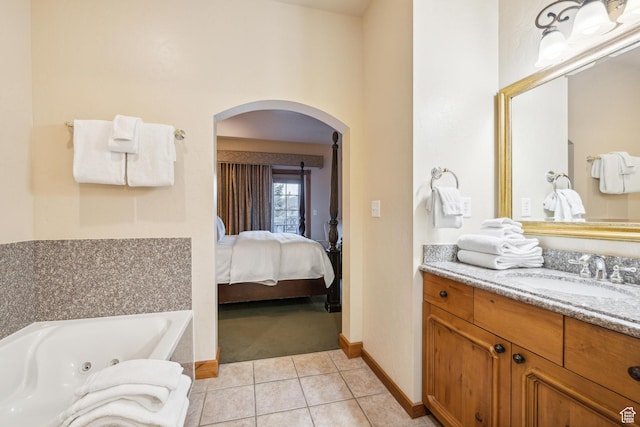 bathroom with tile patterned floors, a tub, and vanity