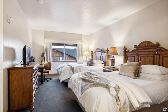 bedroom featuring dark colored carpet and a textured ceiling