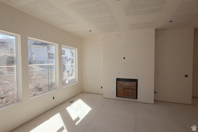 unfurnished living room with a fireplace and a textured ceiling