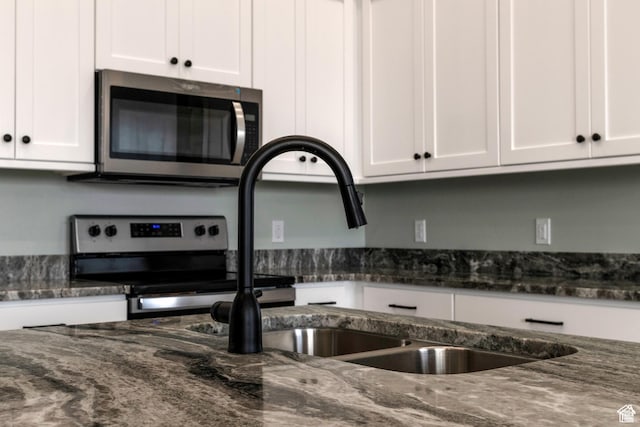 1462 N 4075 W Unit 2, Vernal, UT 84078 - kitchen featuring appliances with stainless steel finishes, white cabinetry, and dark stone counters