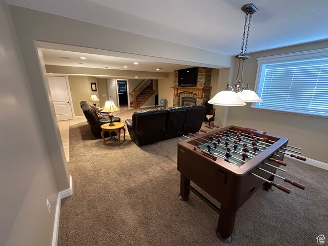 rec room featuring carpet flooring, a stone fireplace, and baseboards