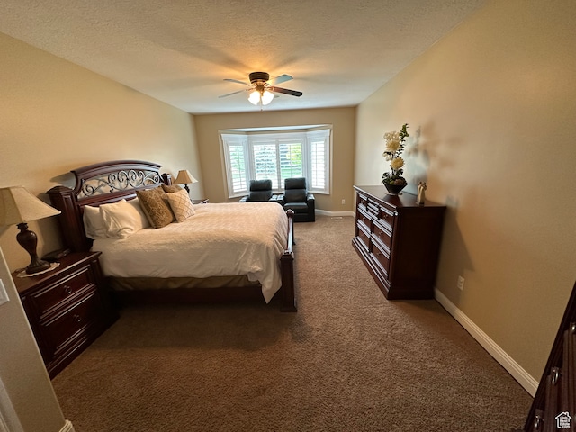 carpeted bedroom featuring baseboards, ceiling fan, and a textured ceiling