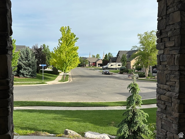 view of road featuring sidewalks, a residential view, and curbs