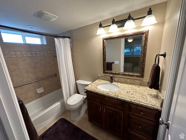 bathroom featuring tile patterned floors, toilet, vanity, shower / bath combo, and a textured ceiling