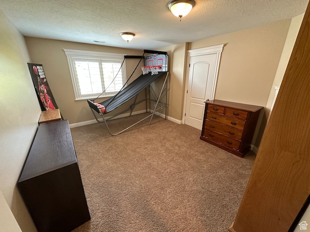 playroom featuring carpet floors, baseboards, visible vents, and a textured ceiling
