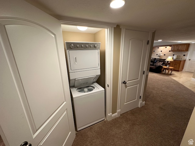 washroom with laundry area, light colored carpet, and stacked washer / drying machine