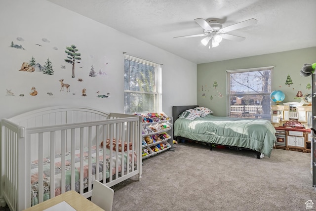 carpeted bedroom featuring a textured ceiling and ceiling fan