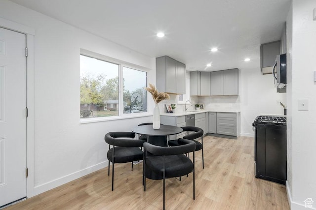 1837 N 440 W, Layton, UT 84041 - kitchen with gray cabinets, black range with gas cooktop, stainless steel microwave, light wood-type flooring, and baseboards