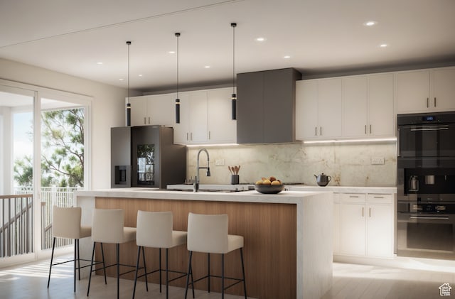 kitchen with white cabinets, stainless steel fridge, light hardwood / wood-style flooring, and an island with sink