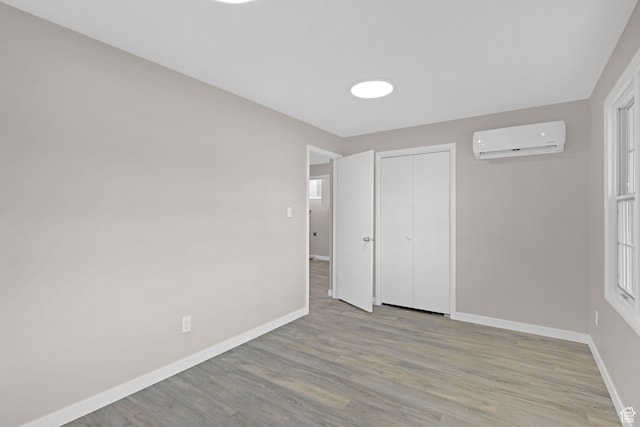 4866 Adams Ave, South Ogden, UT 84403 - unfurnished bedroom with a wall mounted AC, a closet, and light hardwood / wood-style floors