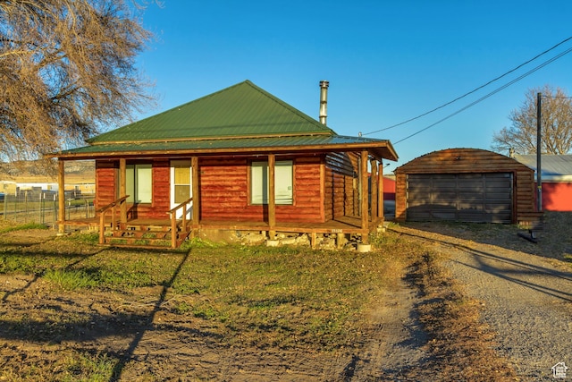 18250 N 4400 W, Fielding, UT 84311 - view of front of property featuring dirt driveway, an outbuilding, metal roof, covered porch, and a detached garage