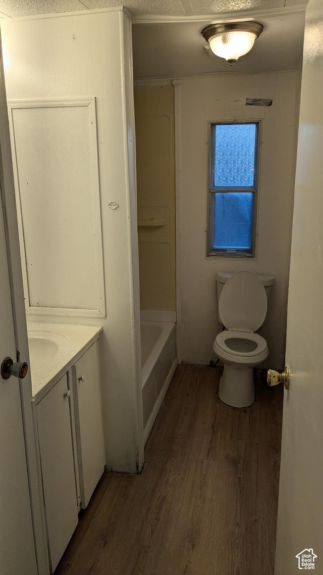 18250 N 4400 W, Fielding, UT 84311 - bathroom featuring wood finished floors, toilet, vanity, and a bath