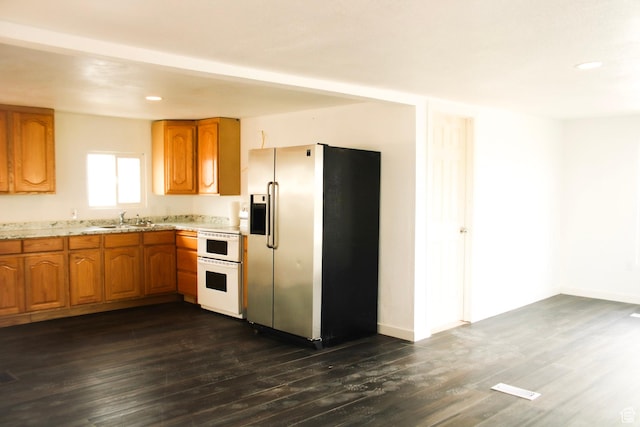 18250 N 4400 W, Fielding, UT 84311 - kitchen featuring stainless steel fridge, double oven range, a sink, brown cabinetry, and dark wood-style flooring