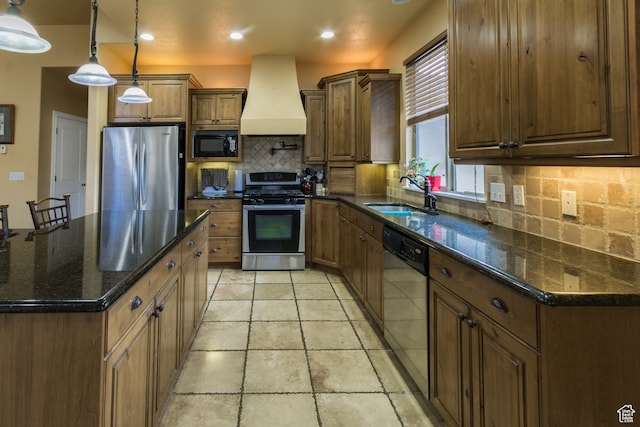kitchen featuring appliances with stainless steel finishes, backsplash, custom exhaust hood, sink, and pendant lighting