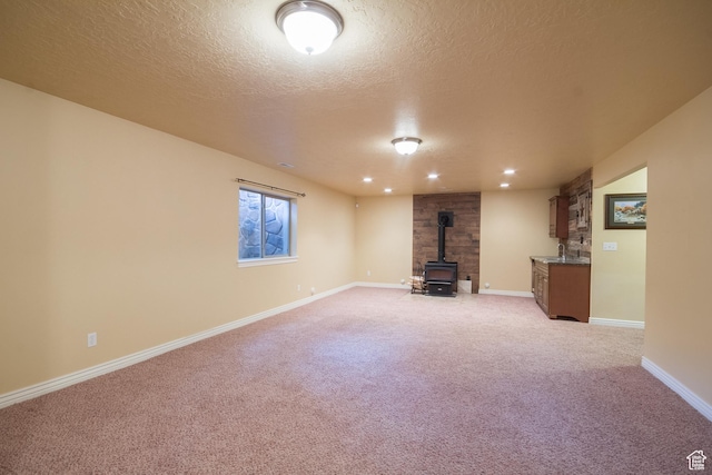 1126 S Valley View Dr W, Santaquin, UT 84655 - basement featuring a wood stove, light colored carpet, a textured ceiling, baseboards, and recessed lighting