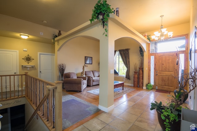 tiled foyer entrance featuring an inviting chandelier