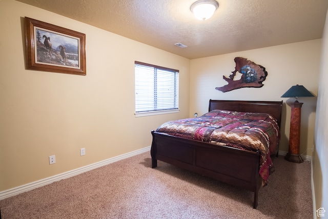 bedroom featuring a textured ceiling and carpet floors
