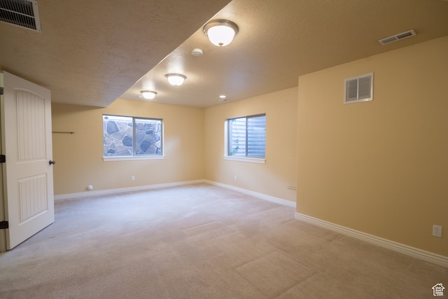 carpeted spare room featuring a textured ceiling