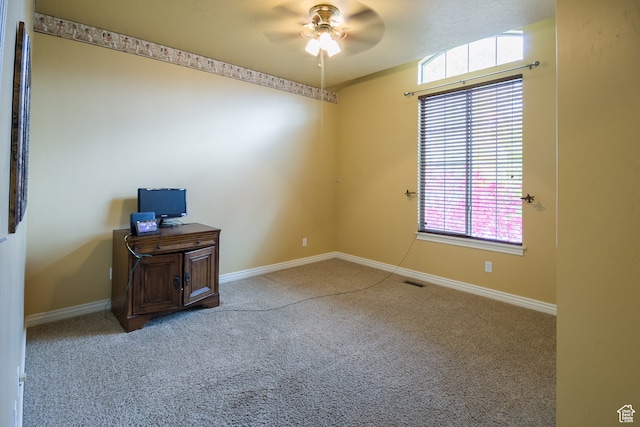 carpeted spare room featuring ceiling fan