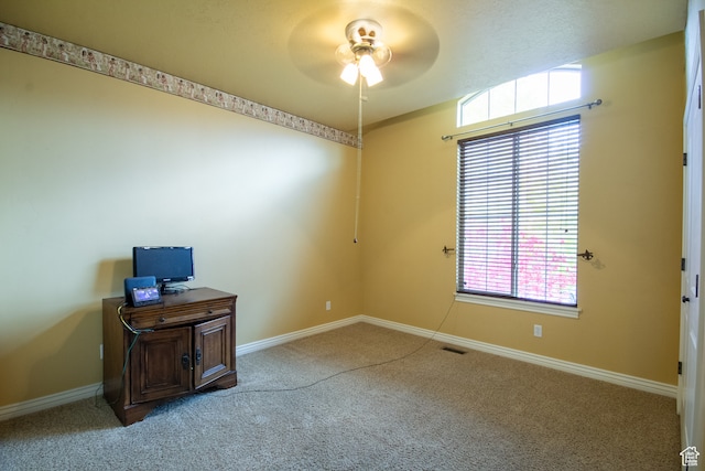 carpeted office space featuring ceiling fan