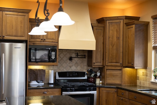 kitchen featuring backsplash, pendant lighting, premium range hood, and appliances with stainless steel finishes