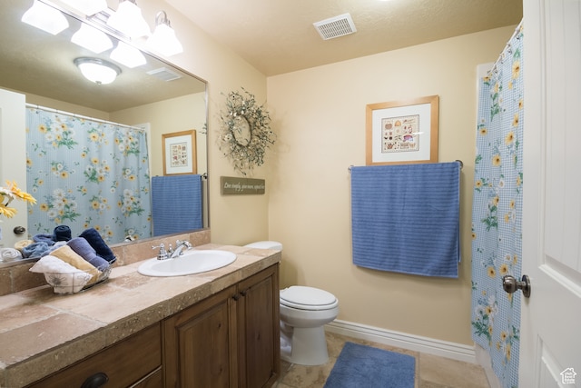 bathroom featuring toilet, vanity, and tile patterned floors