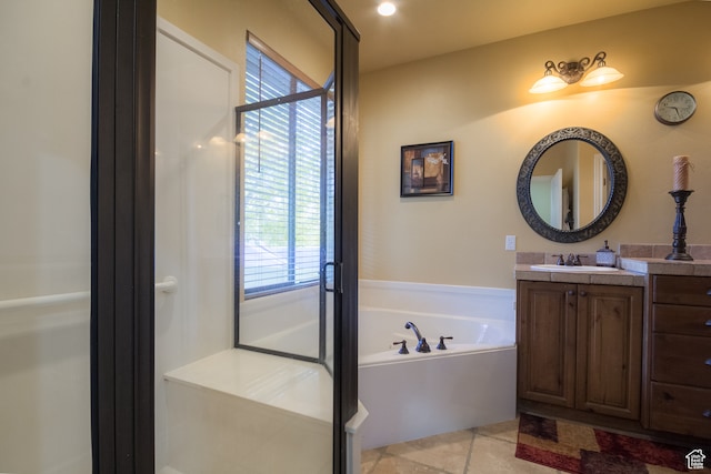 bathroom featuring tile patterned flooring, vanity, and a tub