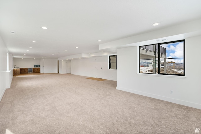 interior space with recessed lighting, light colored carpet, and baseboards