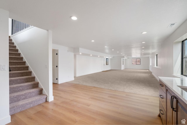 interior space featuring visible vents, recessed lighting, light wood-type flooring, and stairs