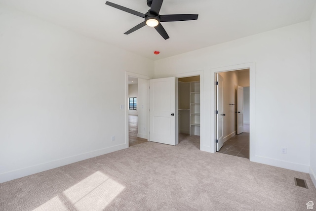 unfurnished bedroom with visible vents, carpet floors, baseboards, and a spacious closet