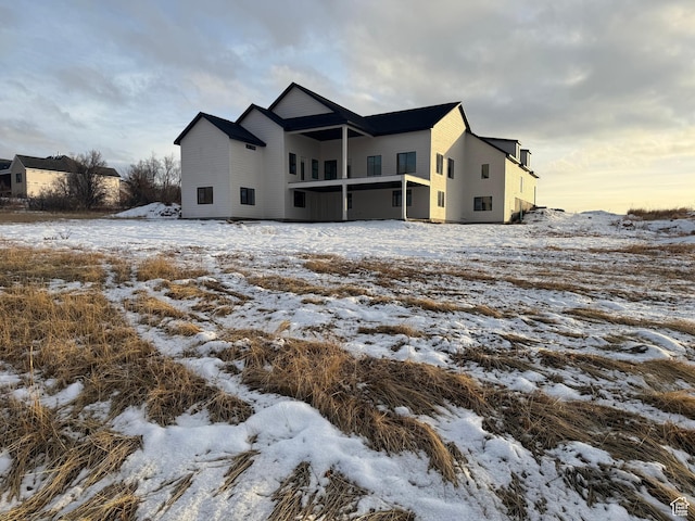 view of snow covered back of property