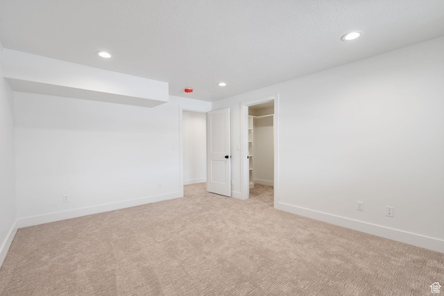 spare room with recessed lighting, light colored carpet, and baseboards