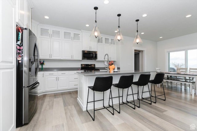 615 N 750 E, Hyde Park, UT 84318 - kitchen with appliances with stainless steel finishes, a sink, light wood-style flooring, white cabinetry, and a breakfast bar area