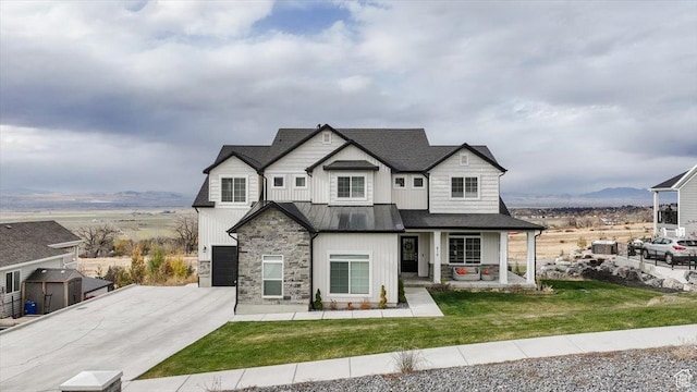 615 N 750 E, Hyde Park, UT 84318 - view of front of house with a standing seam roof, driveway, an attached garage, stone siding, and a front lawn