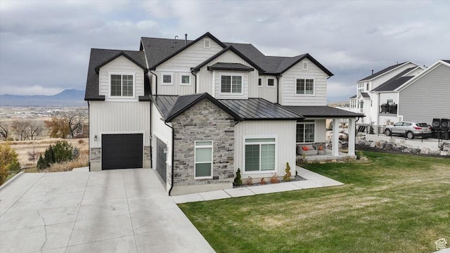 615 N 750 E, Hyde Park, UT 84318 - modern inspired farmhouse with a standing seam roof, concrete driveway, a front yard, board and batten siding, and stone siding