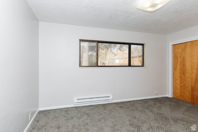 empty room featuring baseboard heating, carpet flooring, and a textured ceiling