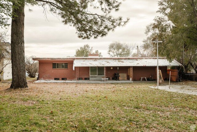 176 W 500 N, Malad City, ID 83252 - rear view of house featuring a chimney, a patio area, a yard, and brick siding