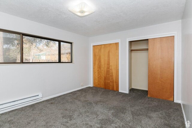 176 W 500 N, Malad City, ID 83252 - unfurnished bedroom with a baseboard heating unit, dark carpet, a textured ceiling, and baseboards