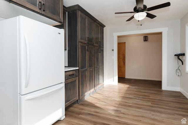kitchen with ceiling fan, hardwood / wood-style floors, dark brown cabinets, and white refrigerator