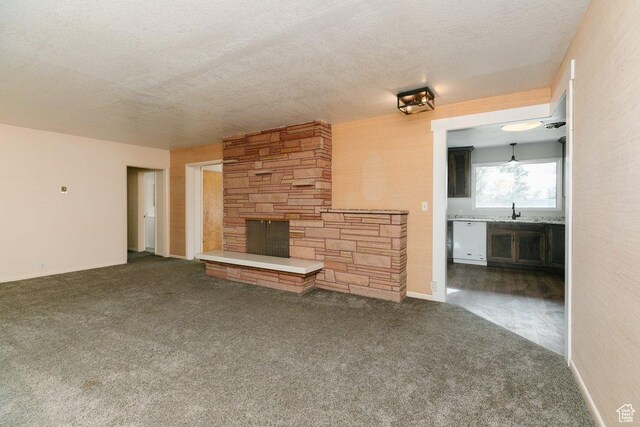 176 W 500 N, Malad City, ID 83252 - unfurnished living room with a stone fireplace, a sink, carpet floors, and a textured ceiling