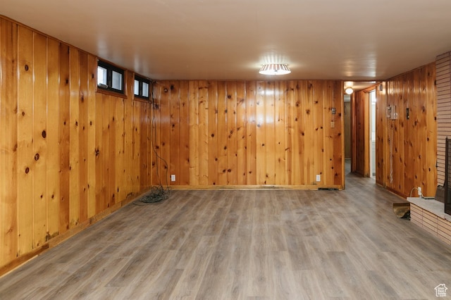 basement featuring hardwood / wood-style floors and wood walls