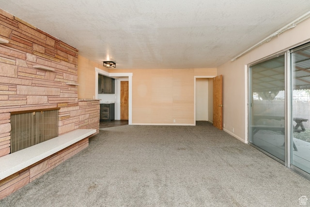 unfurnished living room with a fireplace, carpet floors, and a textured ceiling