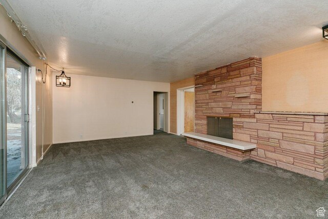 176 W 500 N, Malad City, ID 83252 - unfurnished living room featuring a textured ceiling, a stone fireplace, and carpet floors