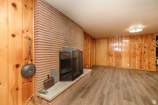 176 W 500 N, Malad City, ID 83252 - unfurnished living room featuring wood finished floors, wooden walls, and a brick fireplace